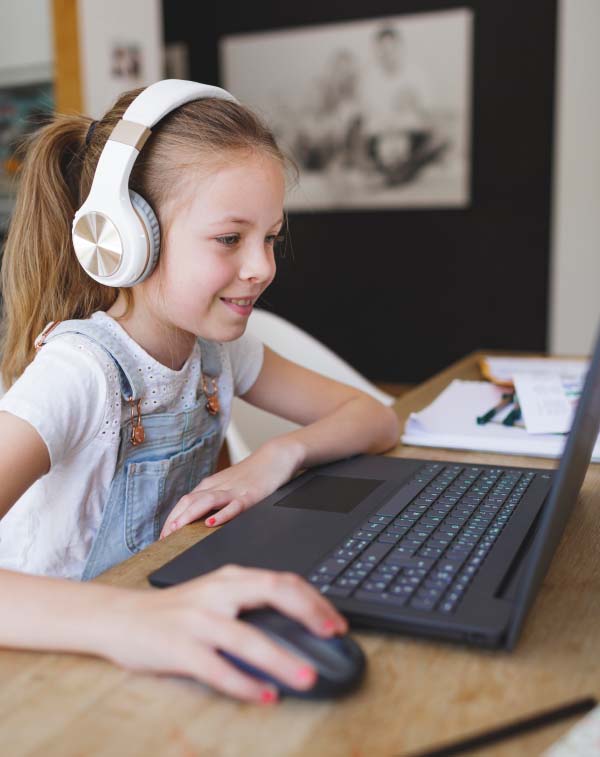 Mädchen mit Kopfhörer arbeitet an ihrem Computer